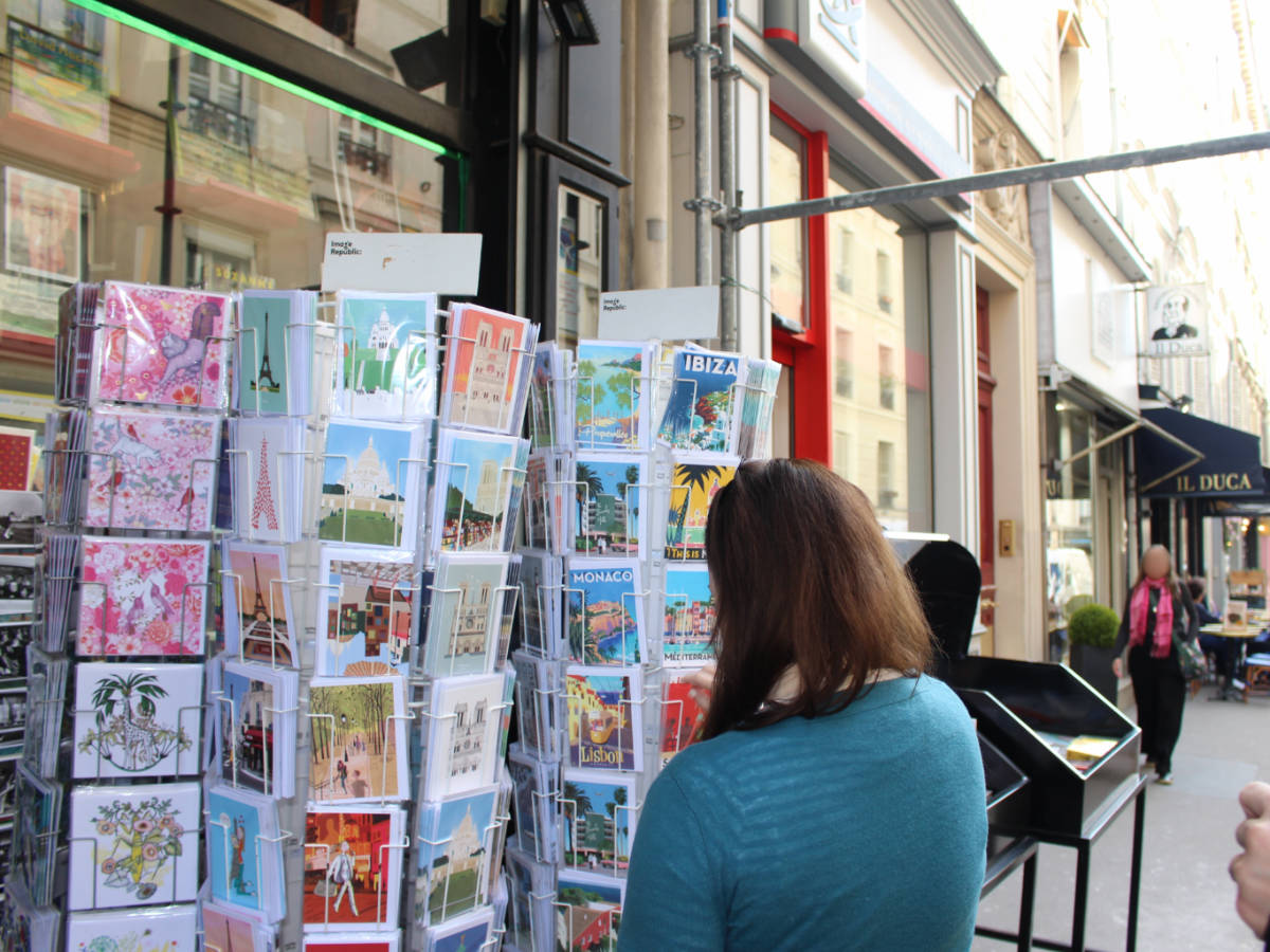 The author, Rachel Kapelke Dale checking postcards near Abbesses