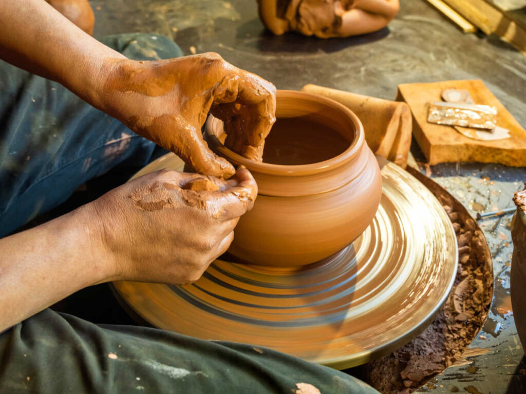 A potter molding clay on a pottery wheel