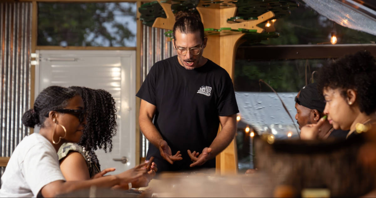 A man teaching the students about cigar rolling