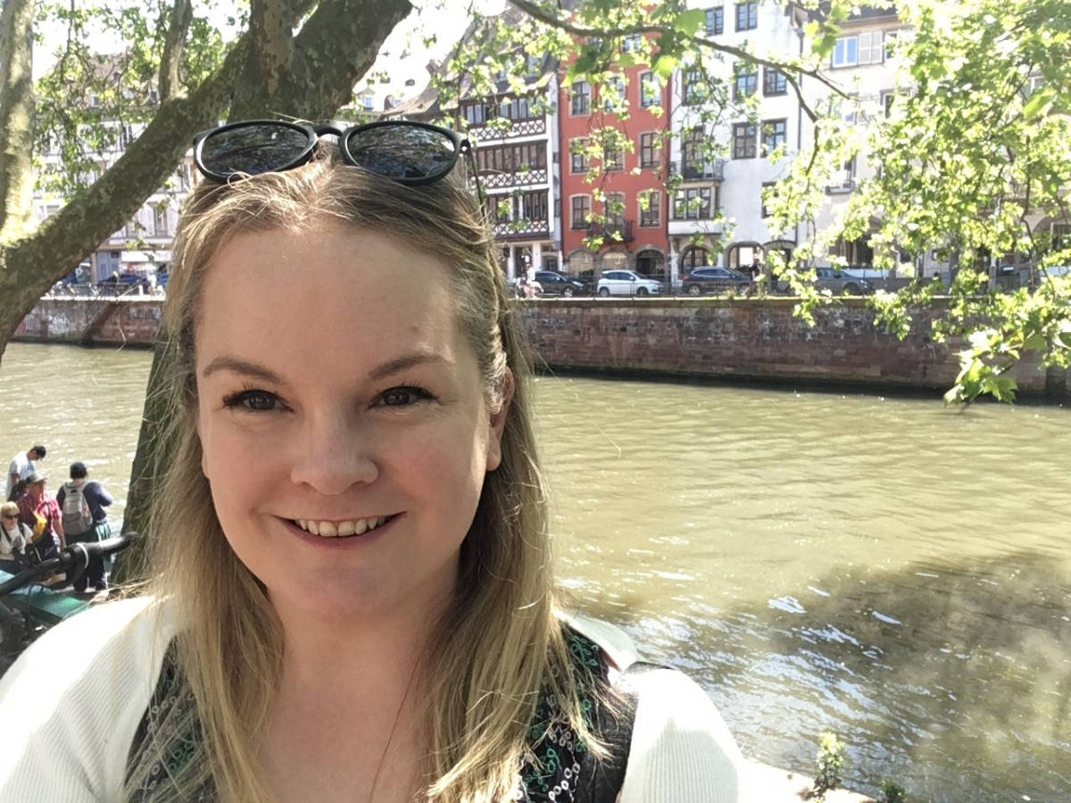 The author Rachel Kapelke-Dale, smiling for a photo near the Boure-side canal