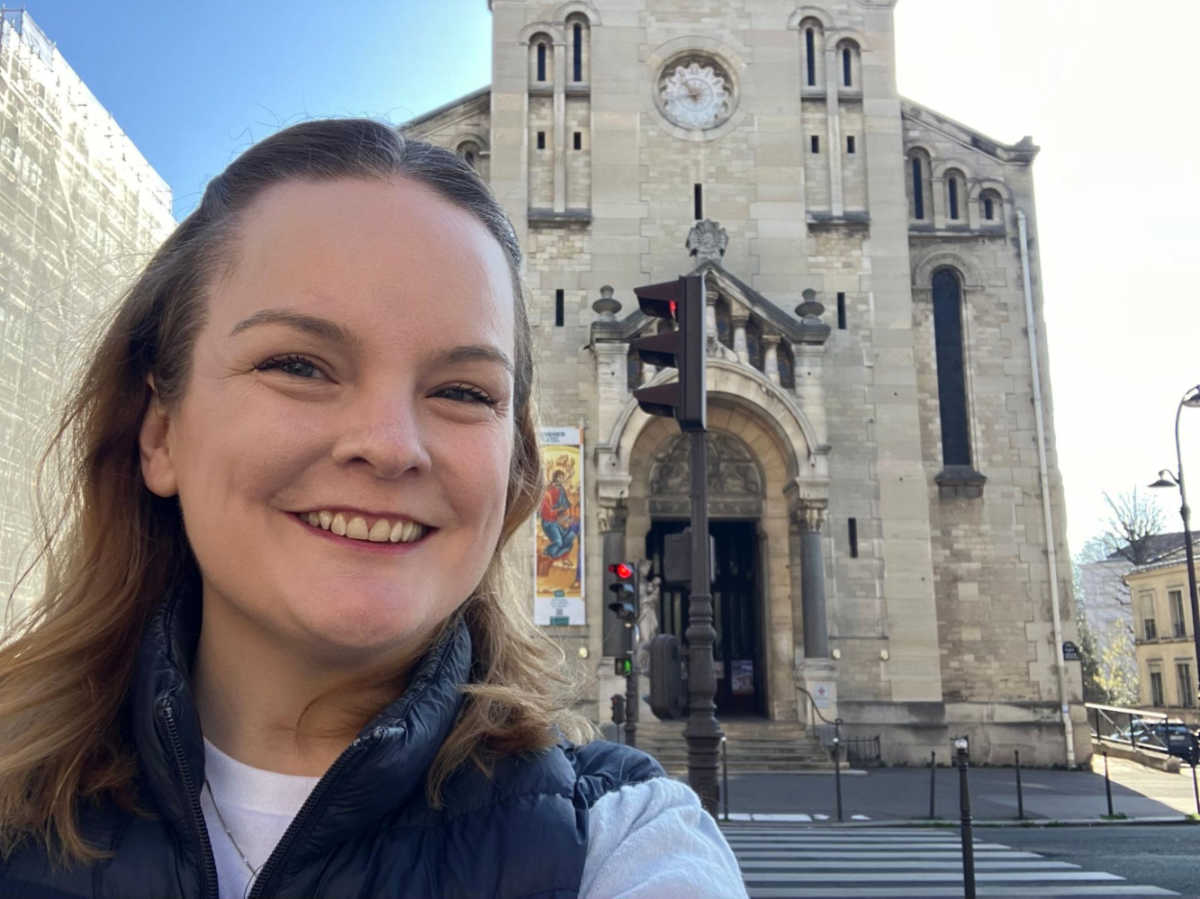 The author, Rachel Kapelke-Dale, smiling for a photo in front of the Église d’Auteuil