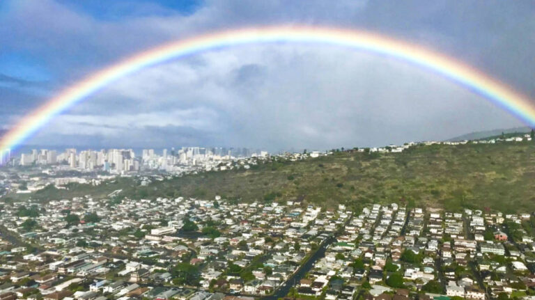 A rainbow over the skyline and mountain of Hawaii