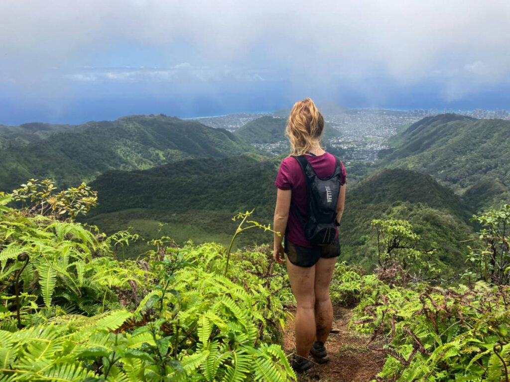 The author Rebecca Parsons admiring the overlooking view of greenery in Hawaii