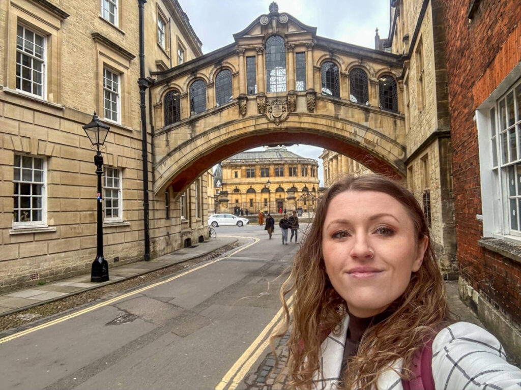 The author Rebecca Rayner, smiling for a photo in front of The Bridge of Sighs