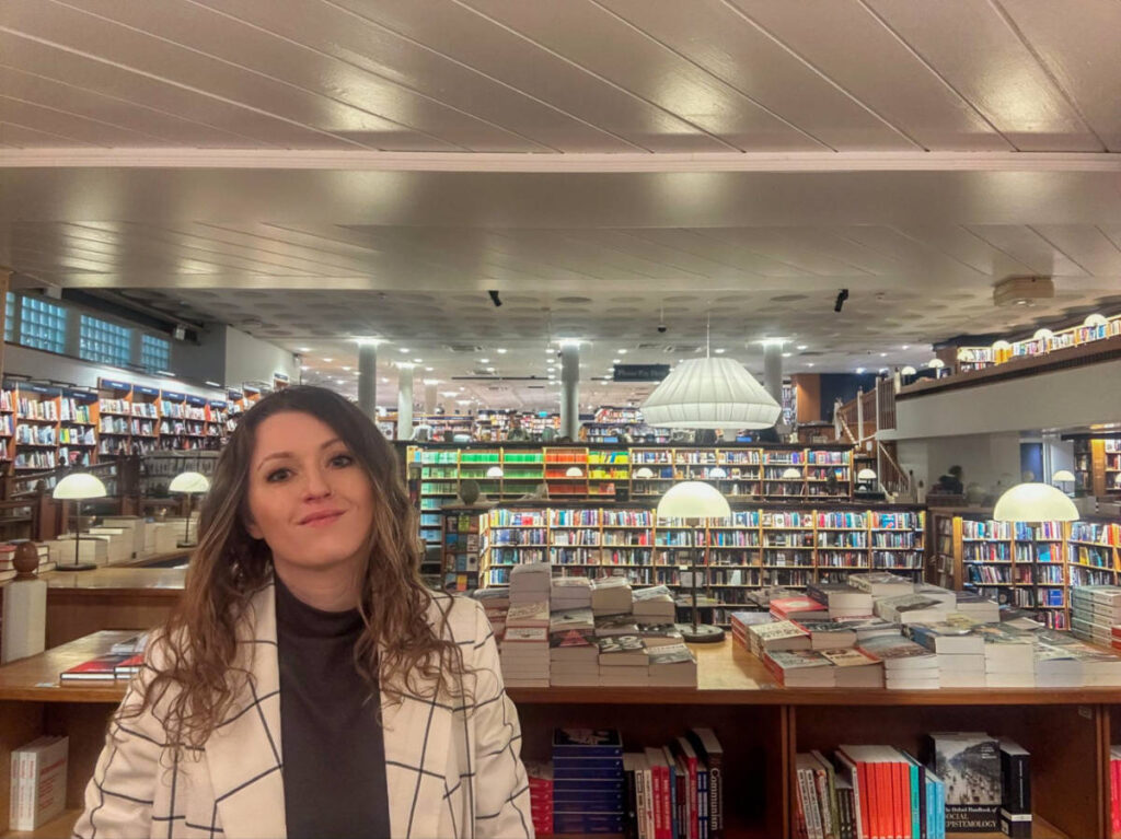 The author Rebecca Rayner, smiling for a photo inside the Blackwells Bookshop