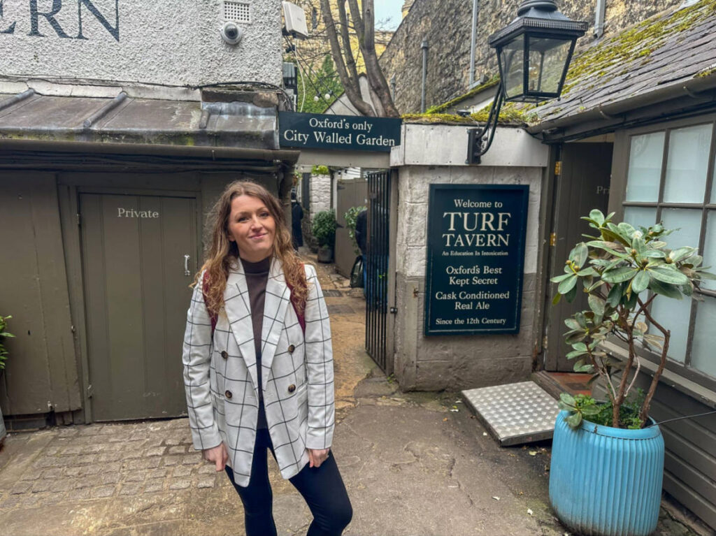 The author Rebecca Rayner, posing for a photo in front of the Turf Tavern