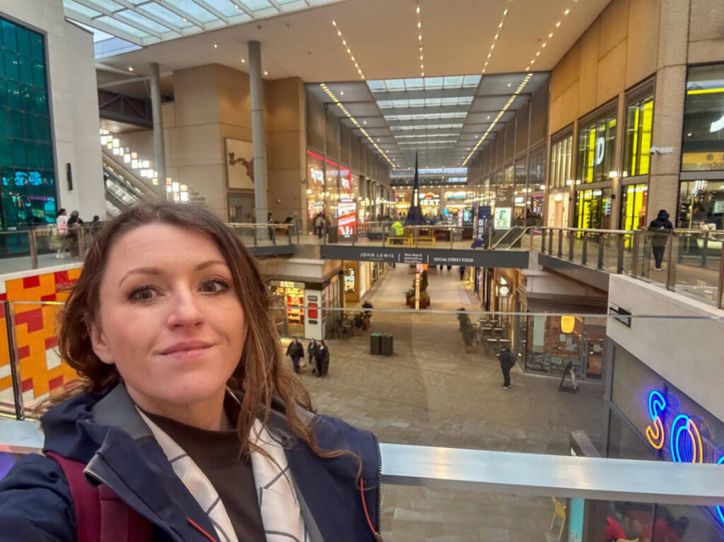 The author Rebecca Rayner, smiling for a photo inside the Westgate Shopping Centre
