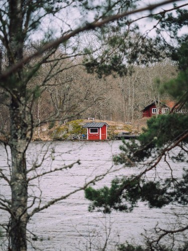 View of the red cabins across the waters in Tyresta