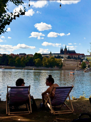 A couple relaxing on the lounge chair with a scenic view of the Čapadlo Summer Terrace