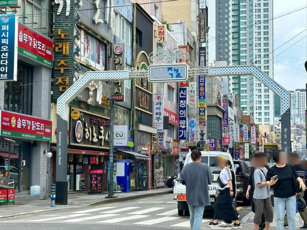 People crossing the street surrounded by famous restaurants in Nampo