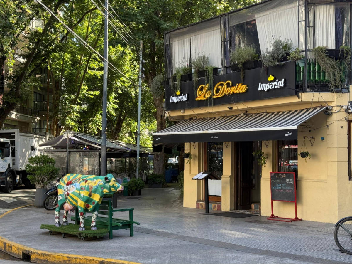 A colorful cow statue in front of a restaurant in Palermo Hollywood