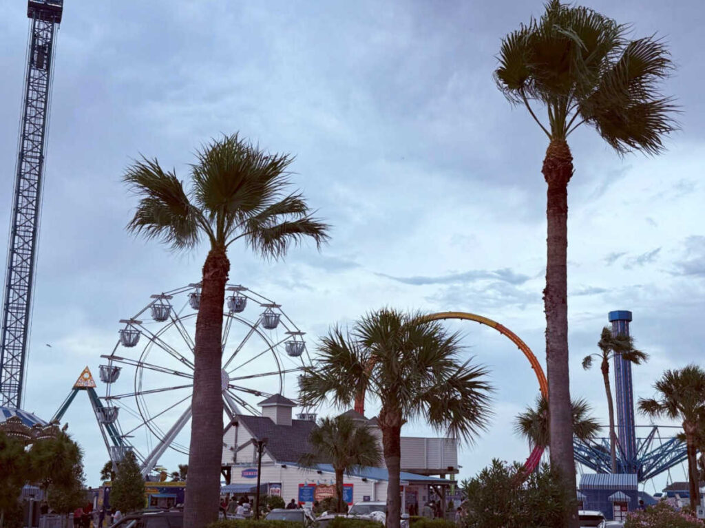 View of the carnival rides and the palm trees around the Kemah Boardwalk