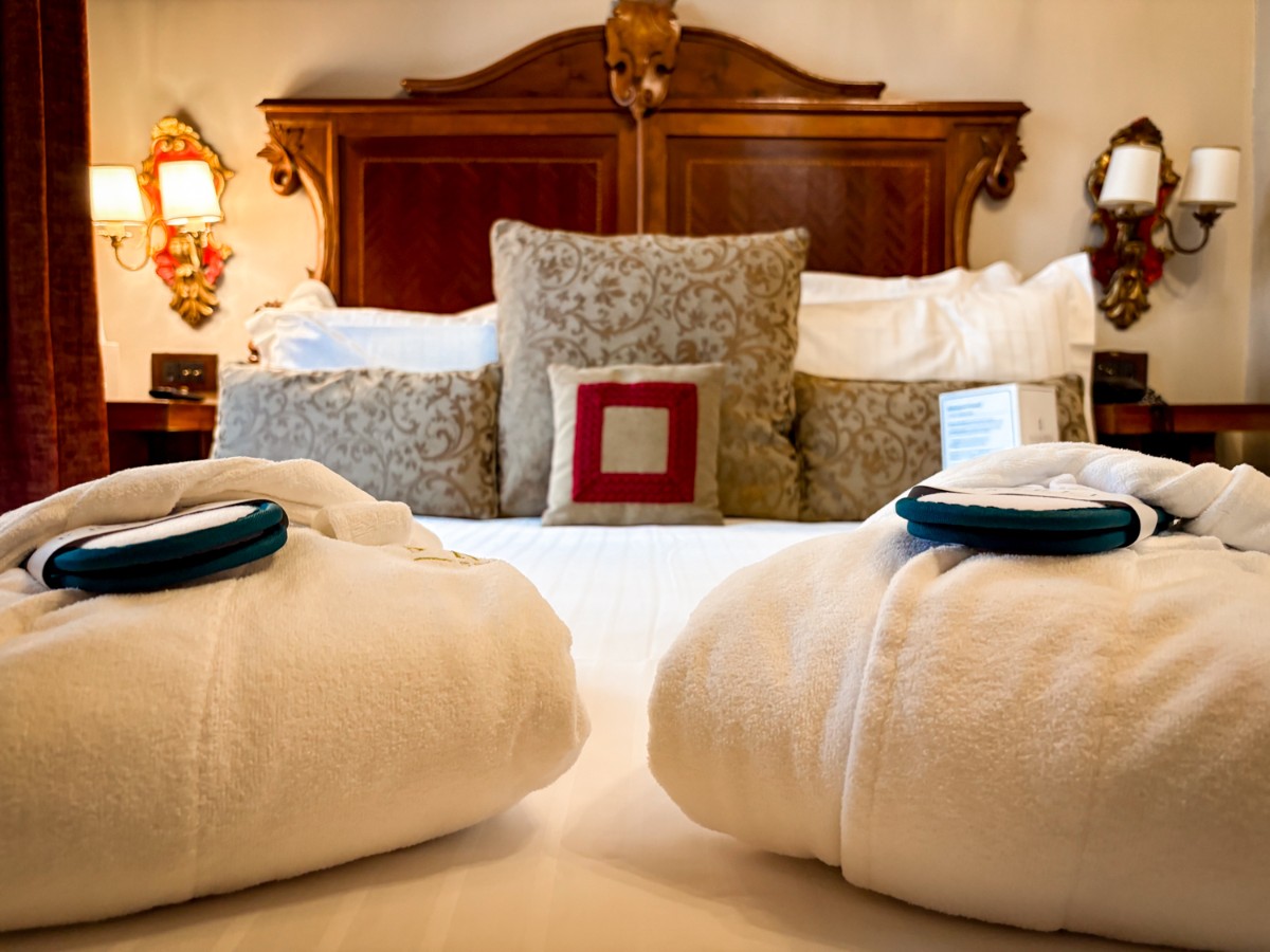 Robes and slippers on the bed at Palazzo Priuli