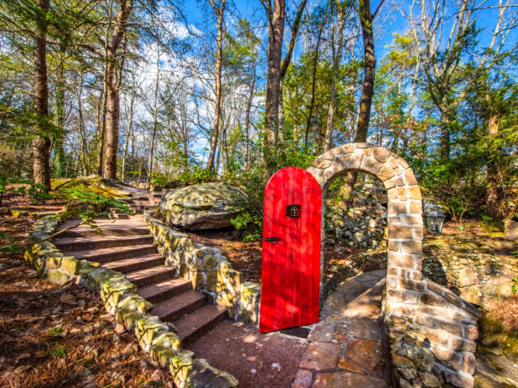 A red door on a stone archway at the Rock City Gardens Trail
