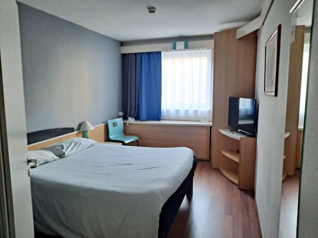 View of the bed and the interior of the room in Ibis Poznań Stare Miasto