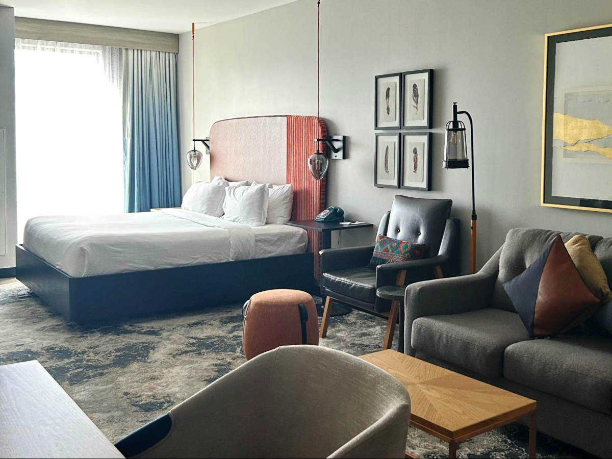 View of the huge bed and the seating area inside the room in Hotel Indigo