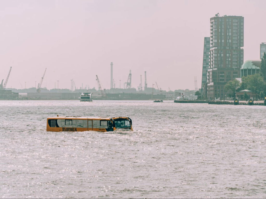 A amphibious bus in the Maas with the view of the city center in the background