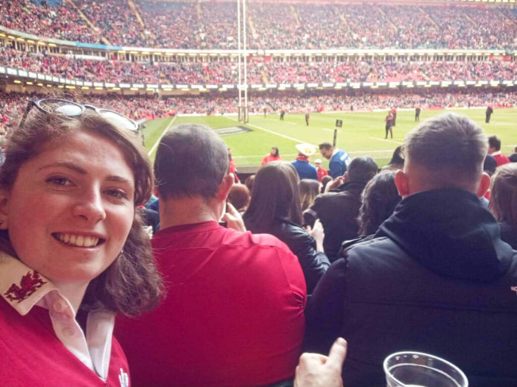 The author Ruthie Walters, smiling for a photo while watching a rugby match at the Principality Stadium
