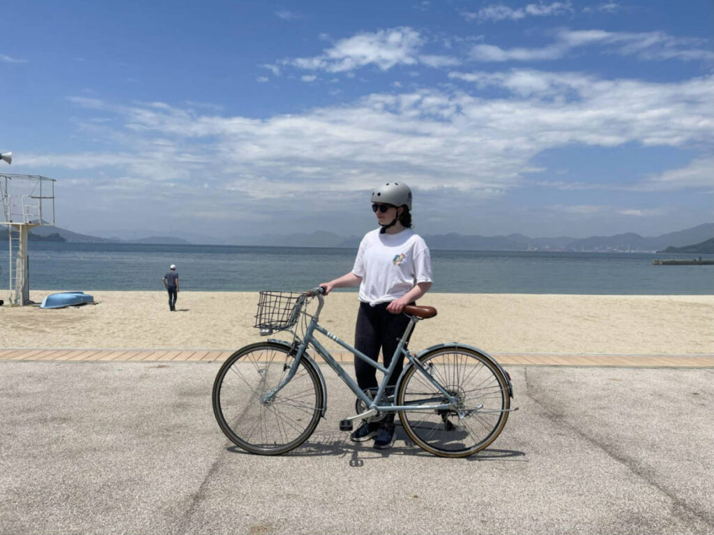 The author Ruthie Walters holding her bicycle at Sunset Beach