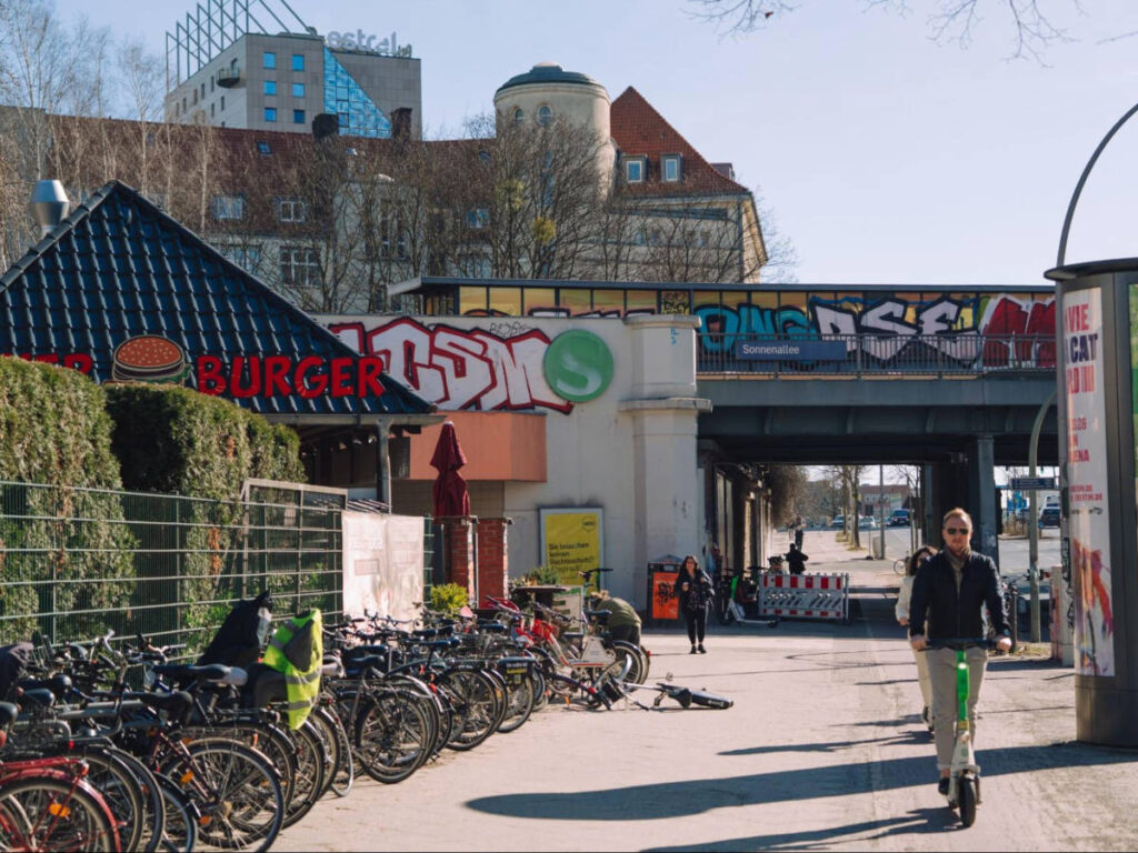 A man riding a scooter near the S-bahn station in Neukölln