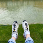 Closeup look of the feet wearing Salomon Trail Runners near the lake