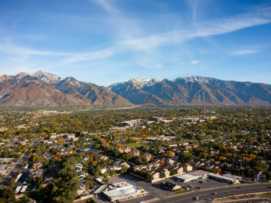Aerial landscape view of the stunning snowcapped rocky mountains of Utah with Salt Lake county below
