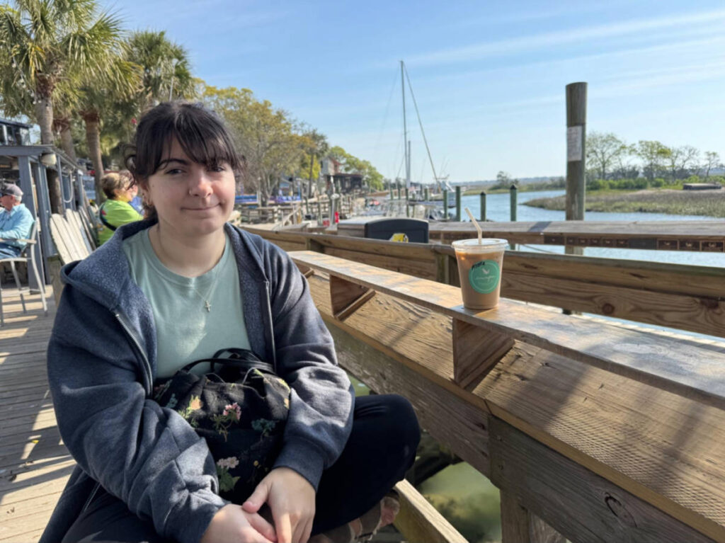 The author's daughter sitting with a cup of coffee with Marshwalk view on the background