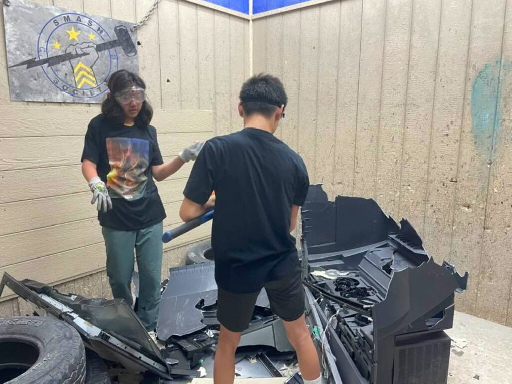 Kids smashing donated electronics and glass at San Antonio Smash Society