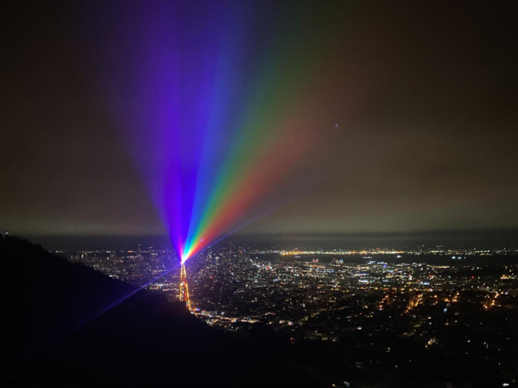 The rainbow lights from the tower at night during the Pride Celebration