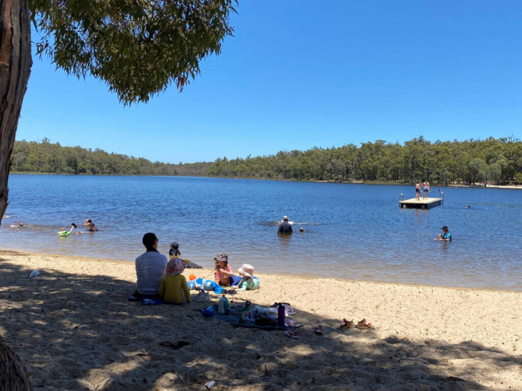 People enjoying the sandy beach at Lake Leschenaultia
