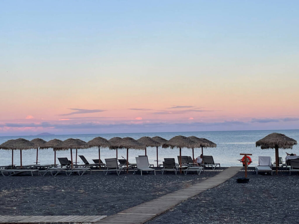 Scenic sunset views from the black sand beach in Santorini