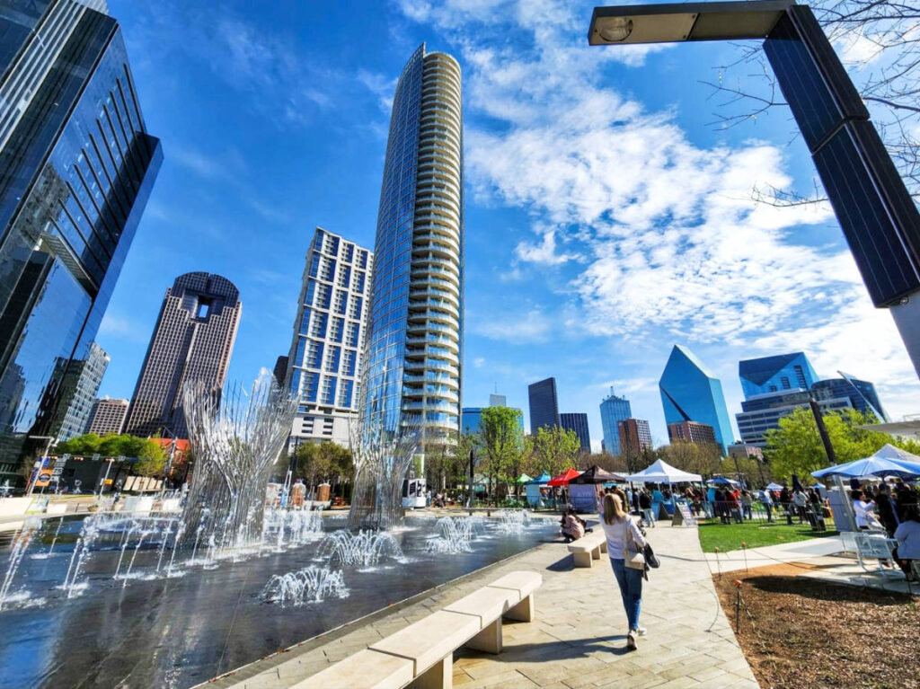 The author Sarah Heath, walking in Kylde Warren Park with the tall buildings in the background