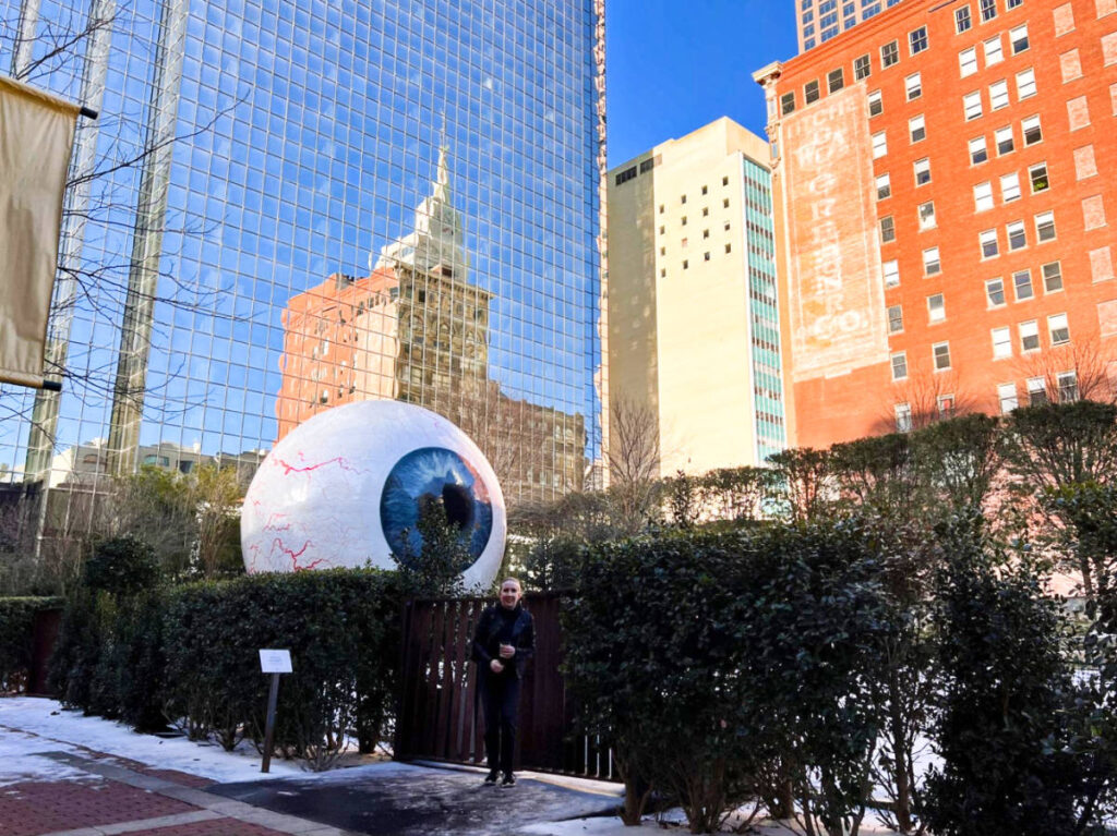 The author Sarah Heath, posing in front of the famous Eyeball Statue in Downtown Dallas