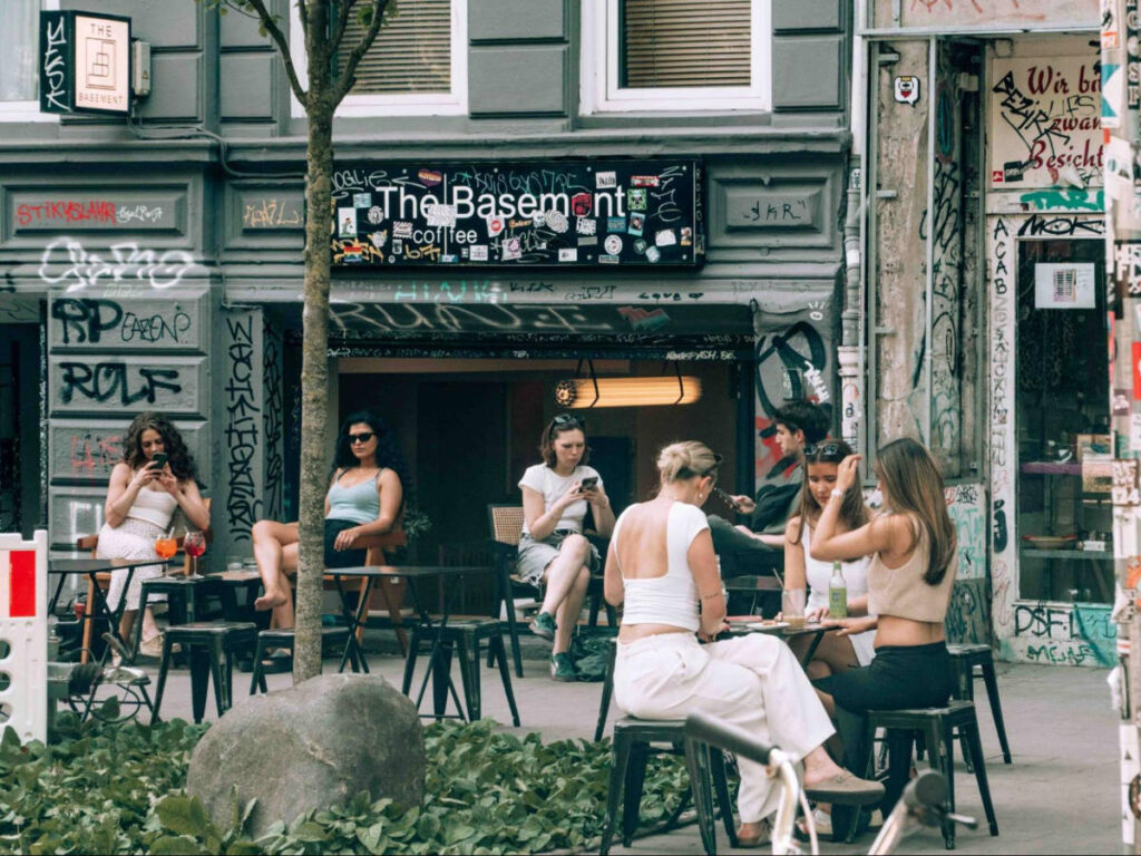 People sitting and chilling at the Schanzenviertel’s terraces with graffiti around