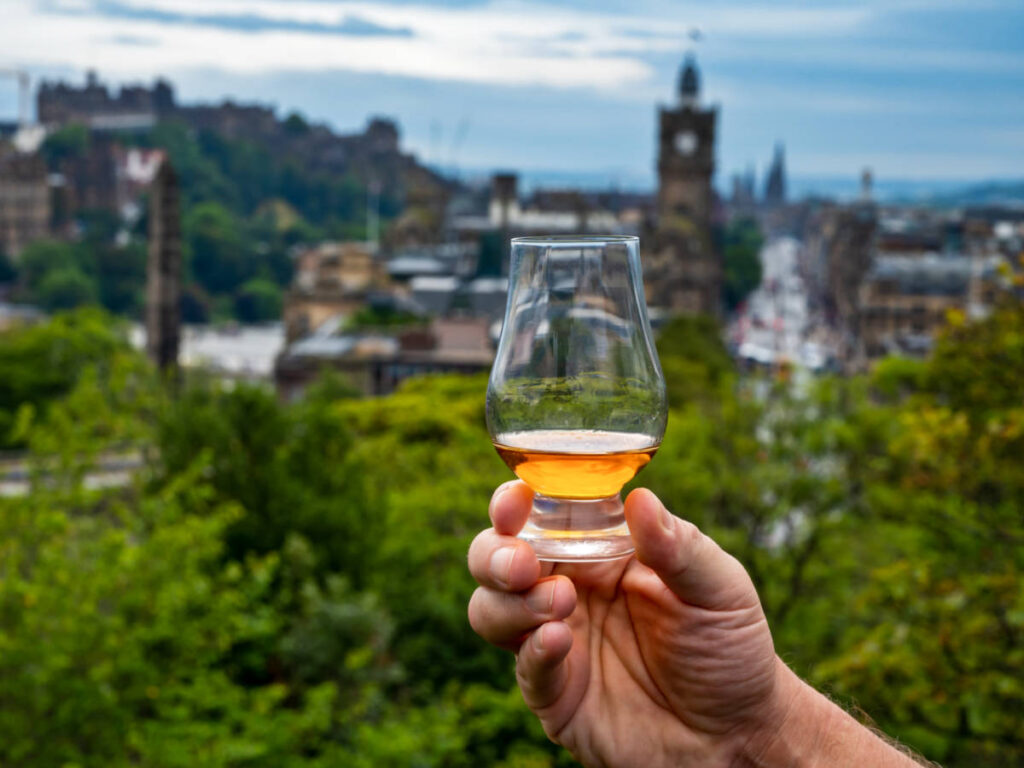 A hand holding a glass of Scotch whisky