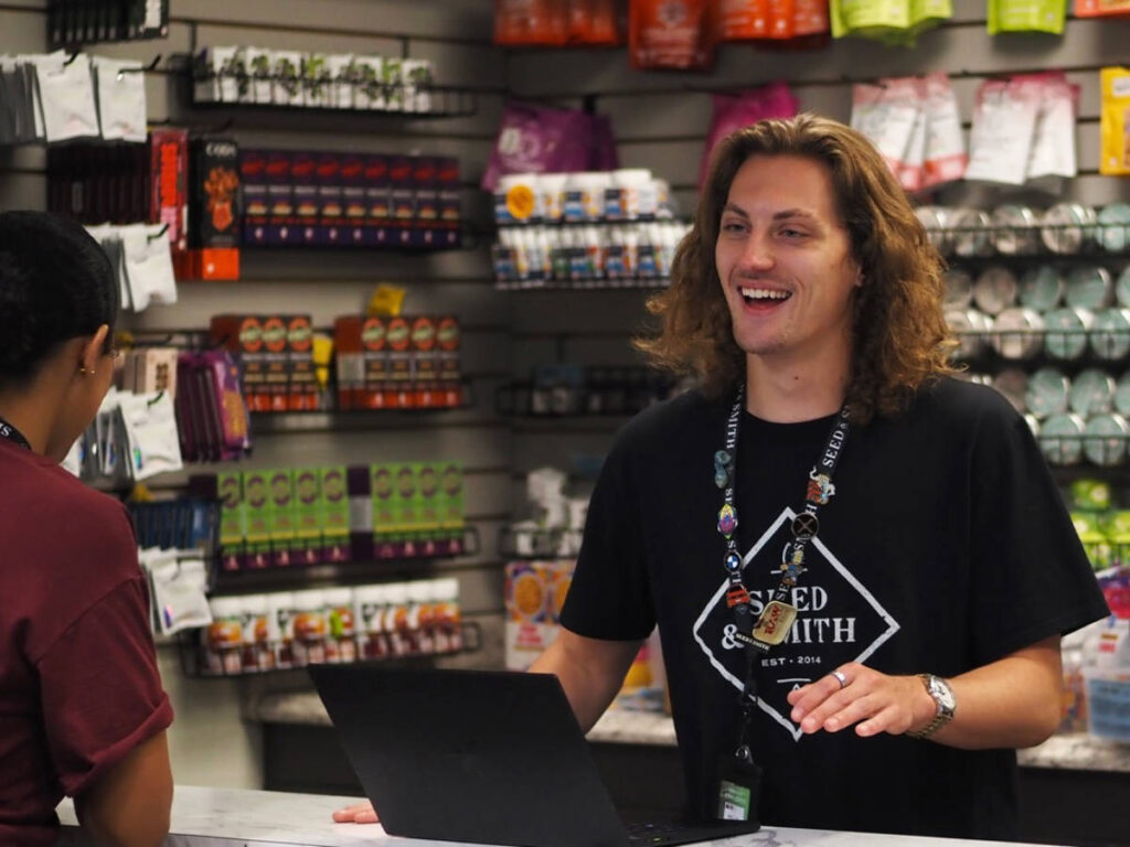 A worker at Seed & Smith welcoming a customer