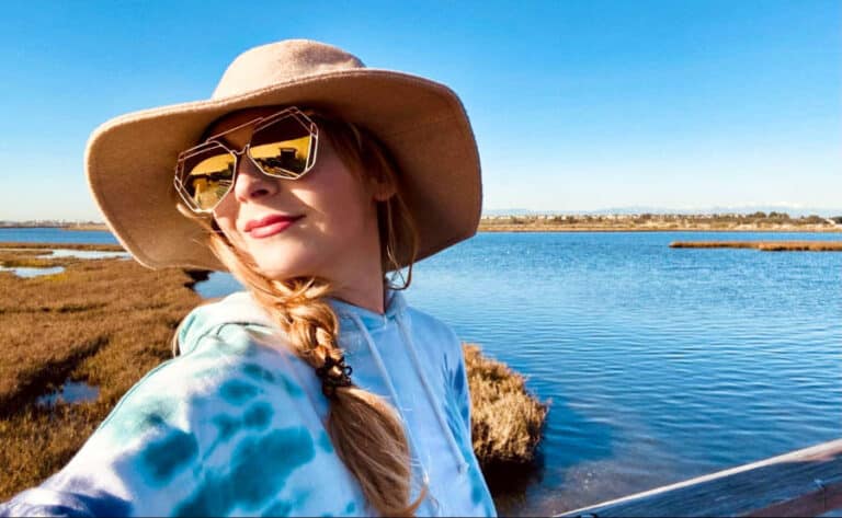The author Jericha Griffin taking a selfie in the Bolsa Chica Wetlands with a clear blue sky in the background