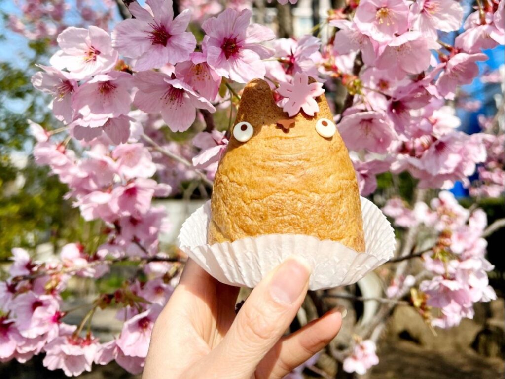 Holding a Totoro cream puff during cherry blossom season