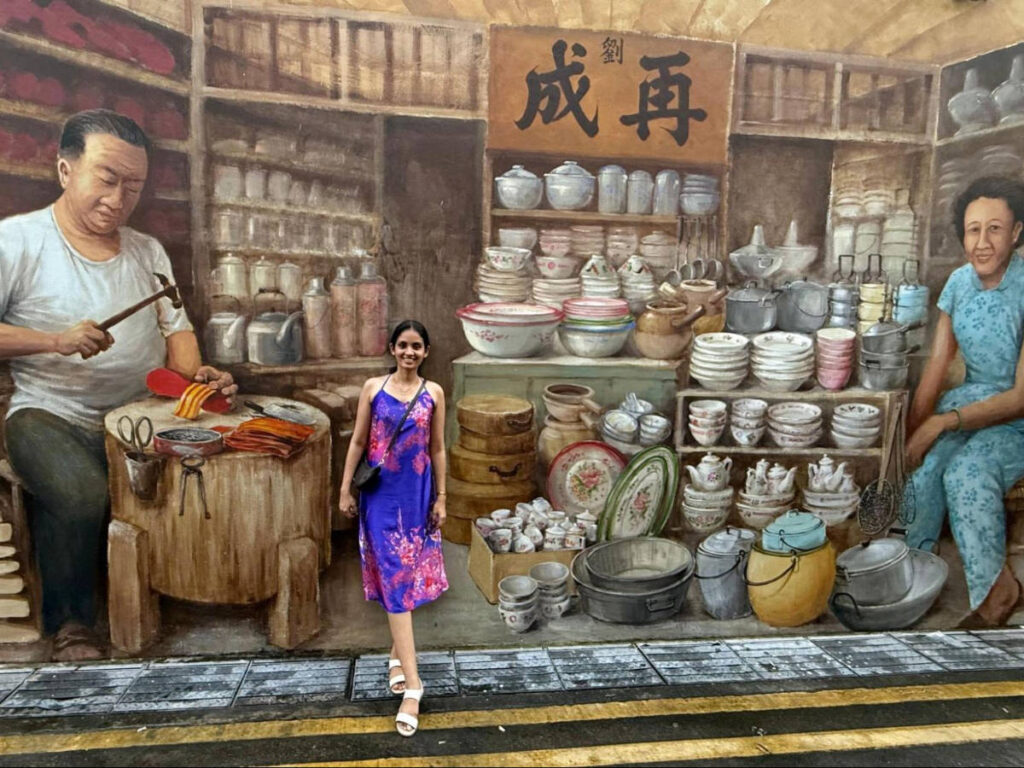 The author, Advaita with a mural on her background in Singapore’s Chinatown