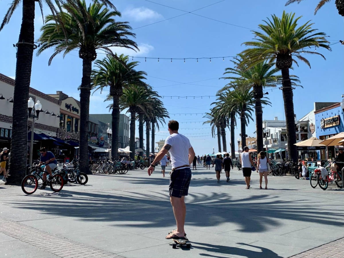 A man skate boarding by the bars in Hermosa Beach