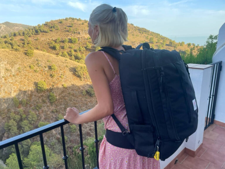 The author Sky Ariella, admiring the overlooking view while carrying her backpack