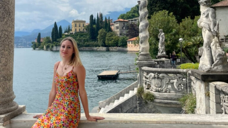 The author Sky Ariella, sitting at the balcony with an overlooking view of Lake Como