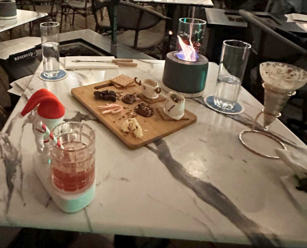 A marbled table with s’mores and drinks