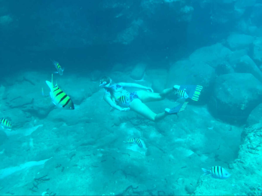 A woman snorkeling with the fishes under the water
