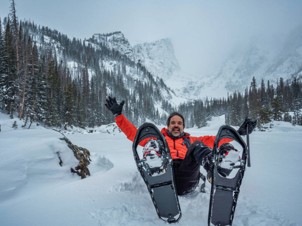 A hiker back dropped by the Dream Lake with magnificent mountain views in the background