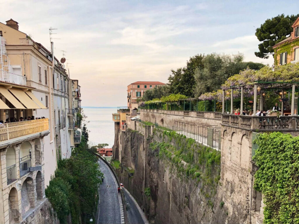 Overlooking view of a street in the middle of the tall buildings in Sorrento at sunset