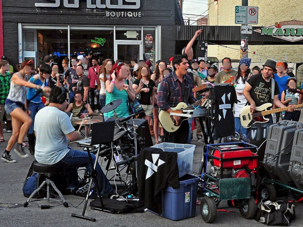 A crowd enjoying the performance of a band on Sixth Street