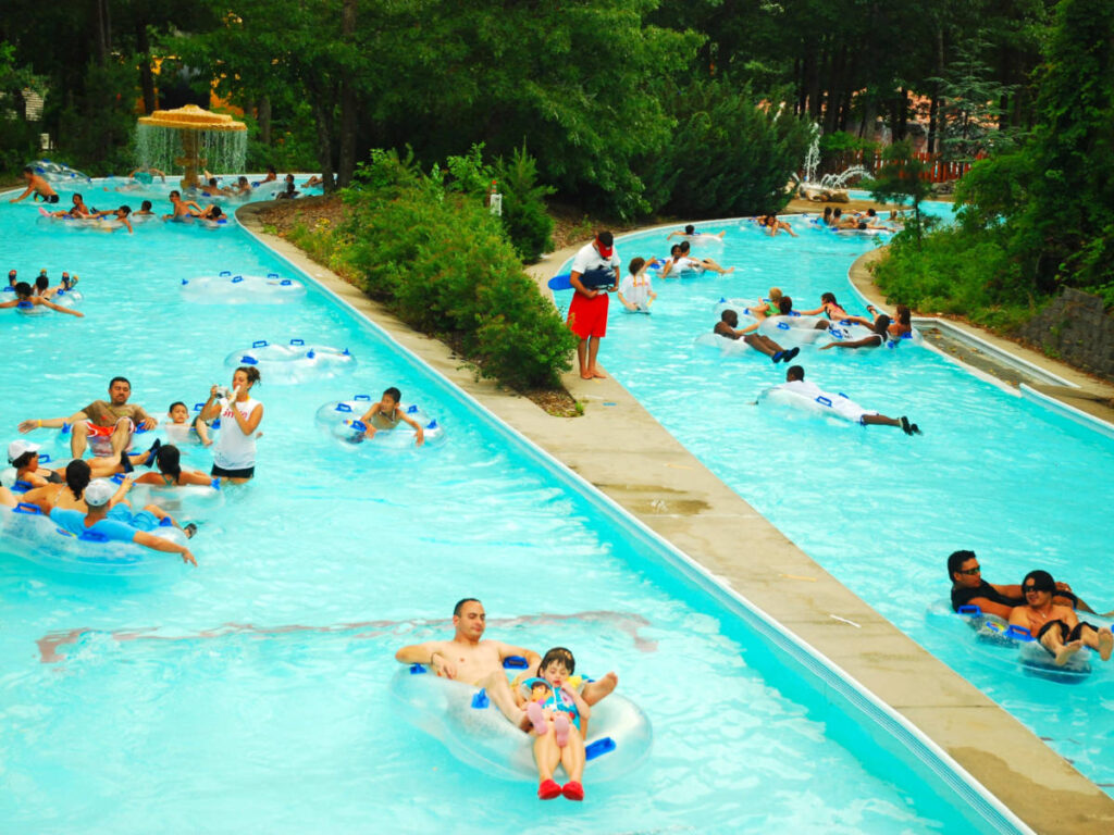 People enjoy floating on inflatable rafts on a lazy river attraction in Splish Splash Water Park