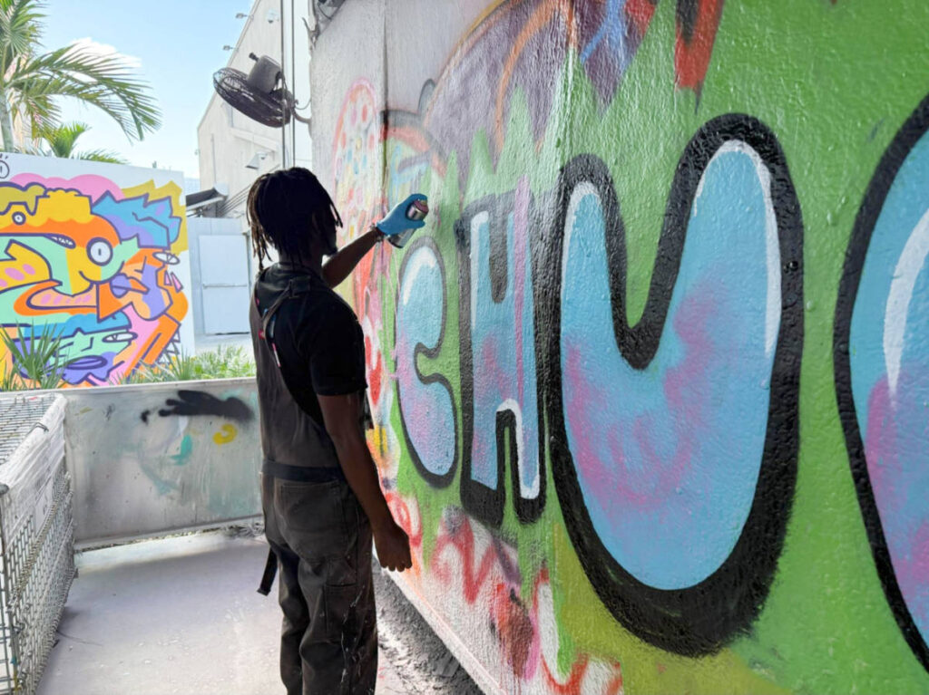 An instructor demonstrates spray painting