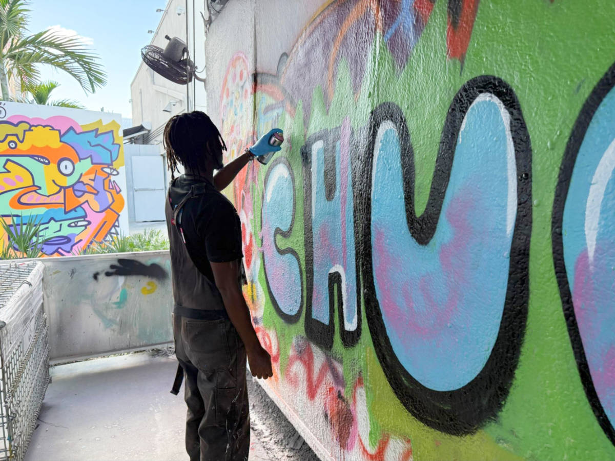 An instructor demonstrates spray painting